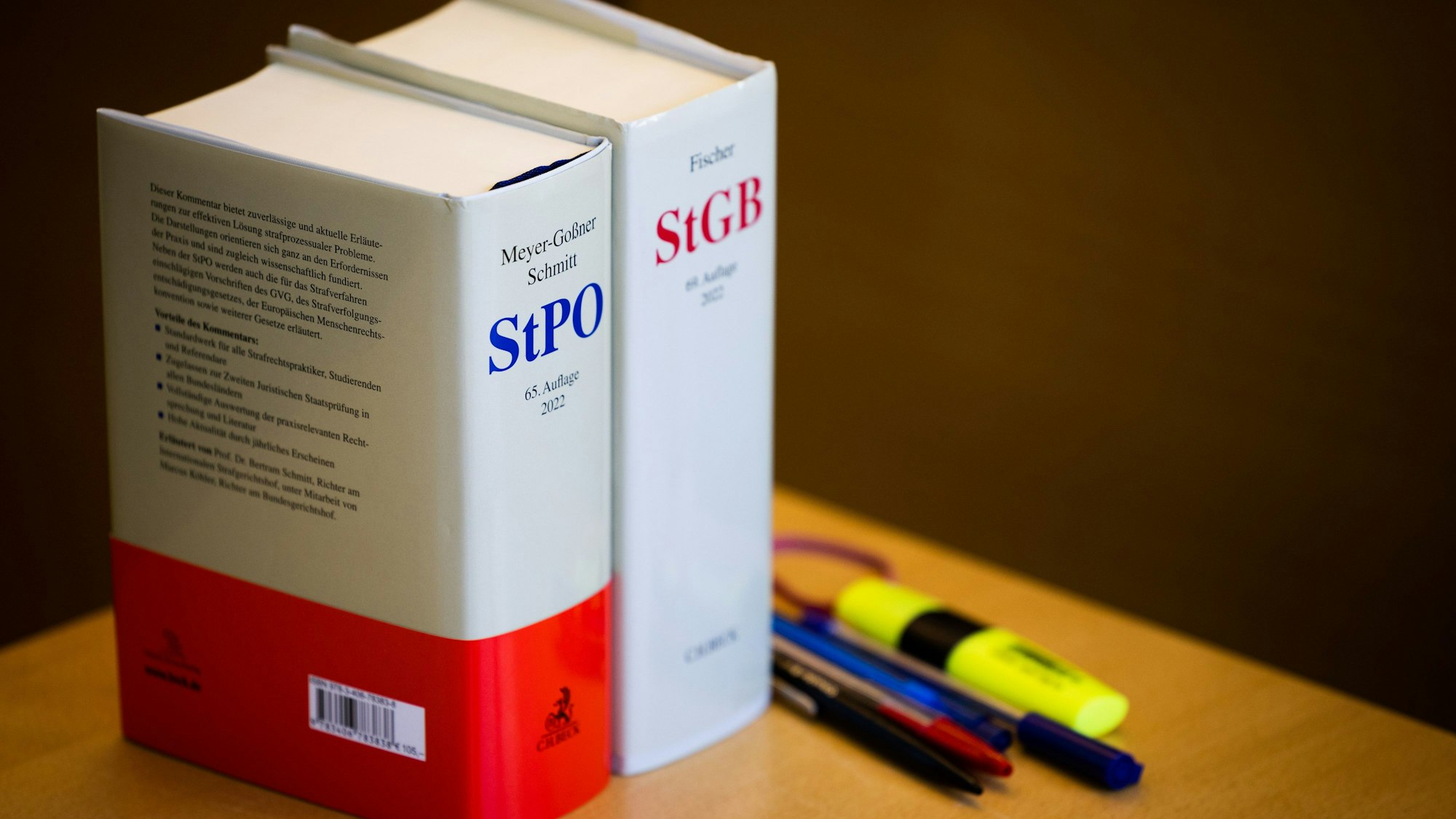 Auf einem Tisch stehen zwei Strafgesetzbücher.