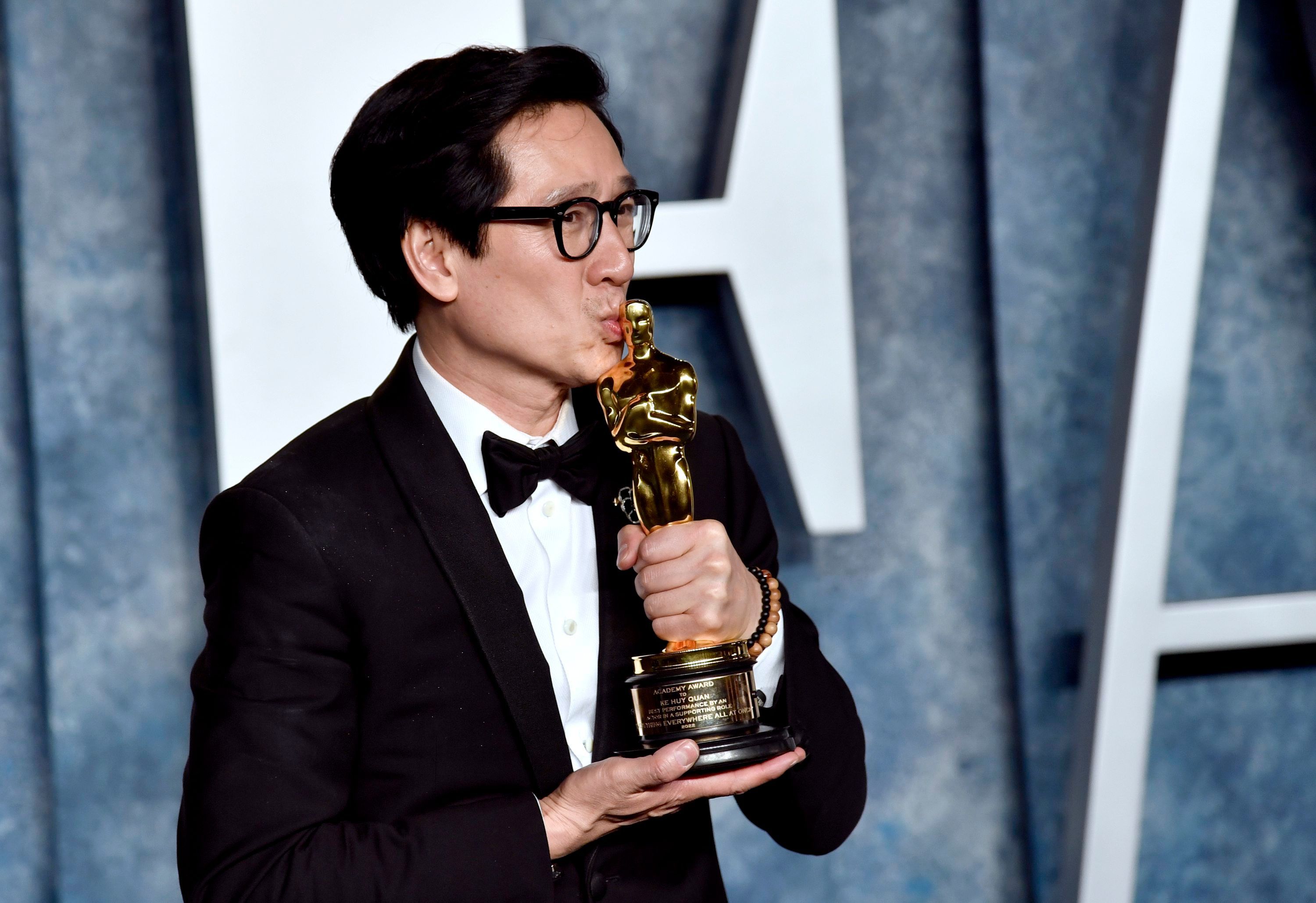 Ke Huy Quan küsst seinen Oscar für die beste Nebenrolle 2023.