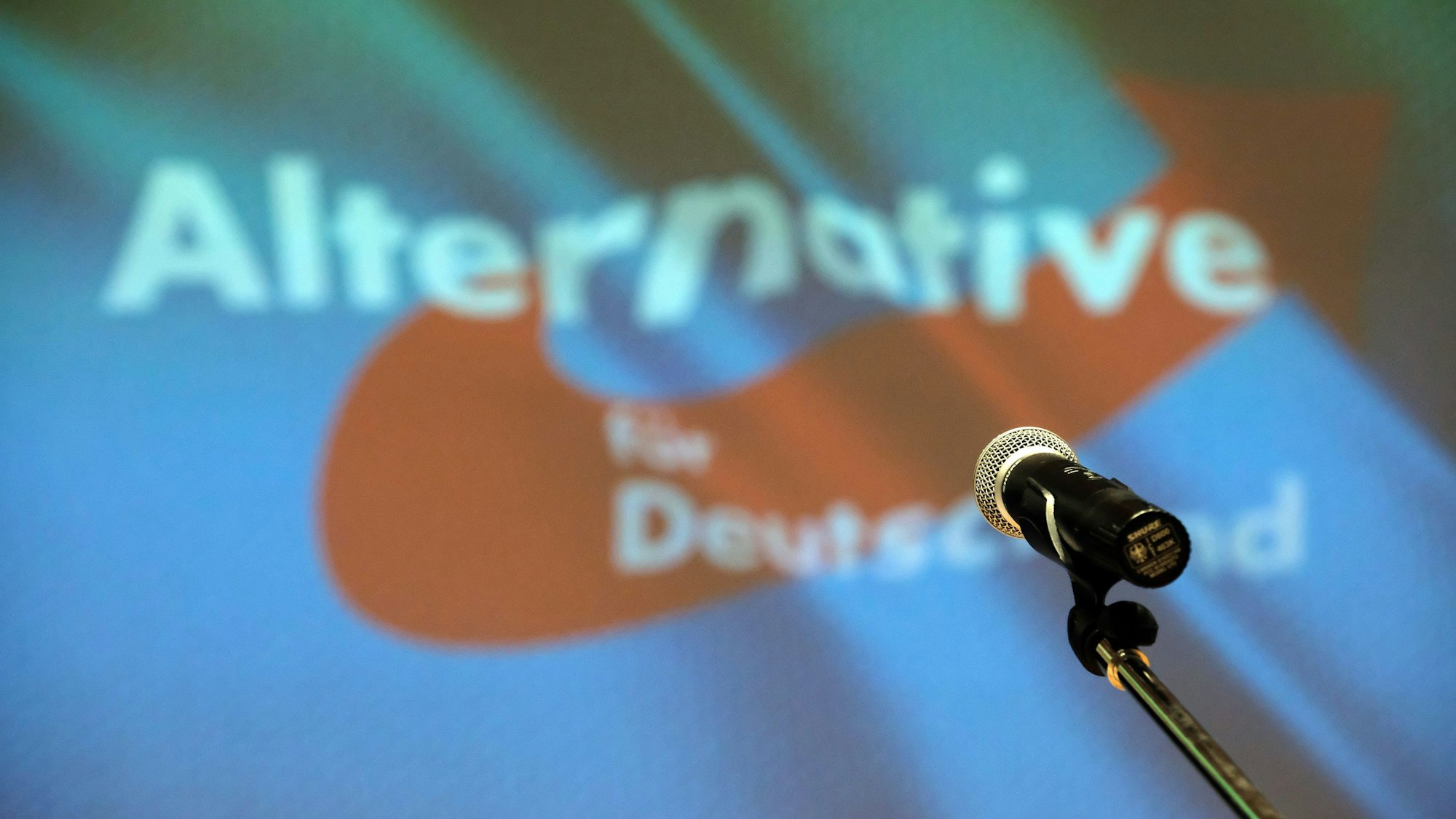 Ein Mikrofon vor einem Banner der AfD
