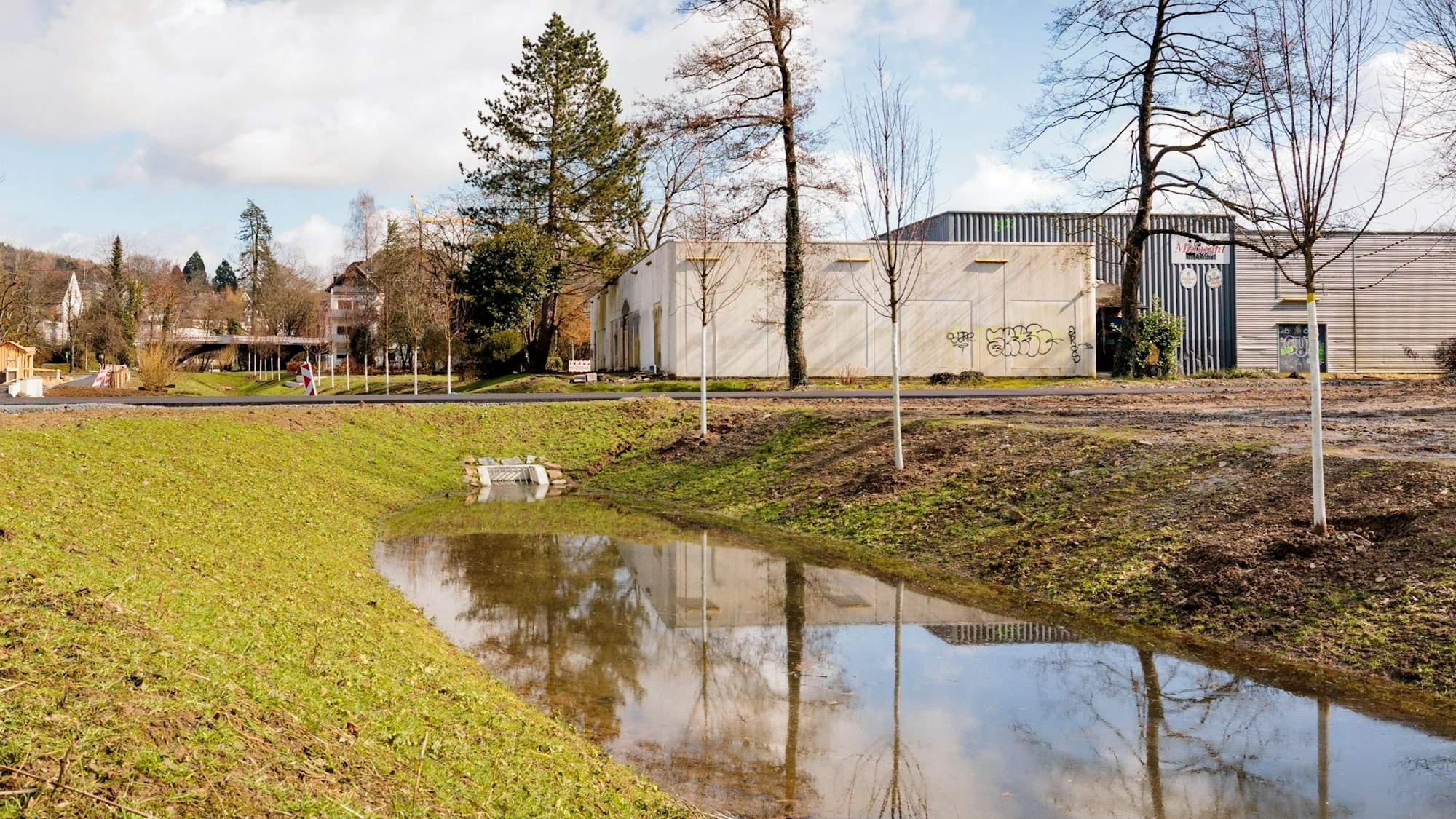 Auf dem Wiehlpark-Gelände ist ein Kanal zu sehen, dahinter eine Gewerbebrache.