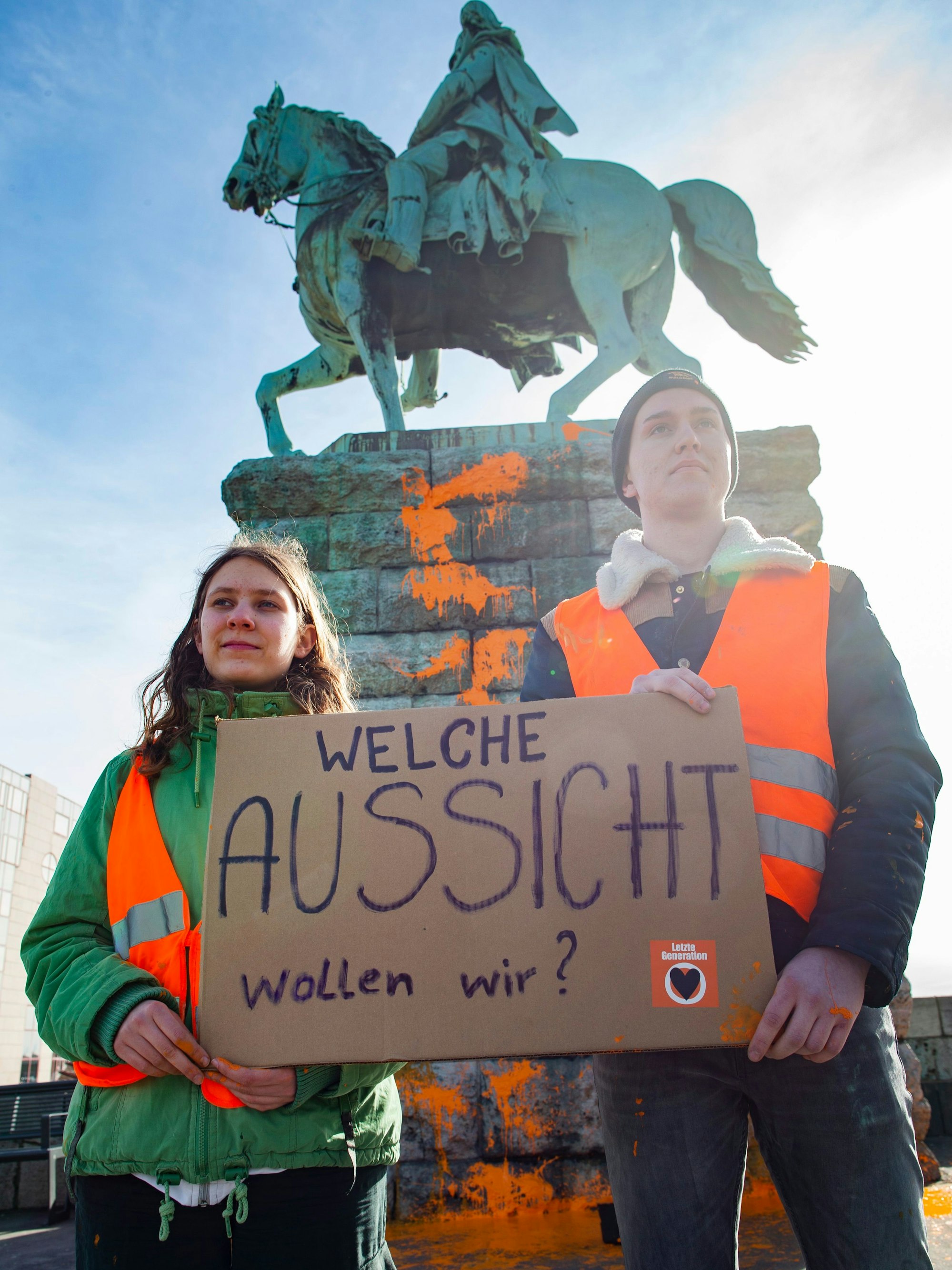 Zwei Aktivisten stehen vor dem Reiterdenkmal.Thomas Banneyer