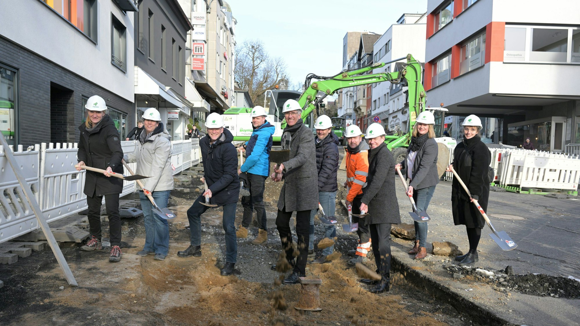 Die Beteiligten nehmen den offiziellen Spatenstich an der Baustelle vor.
