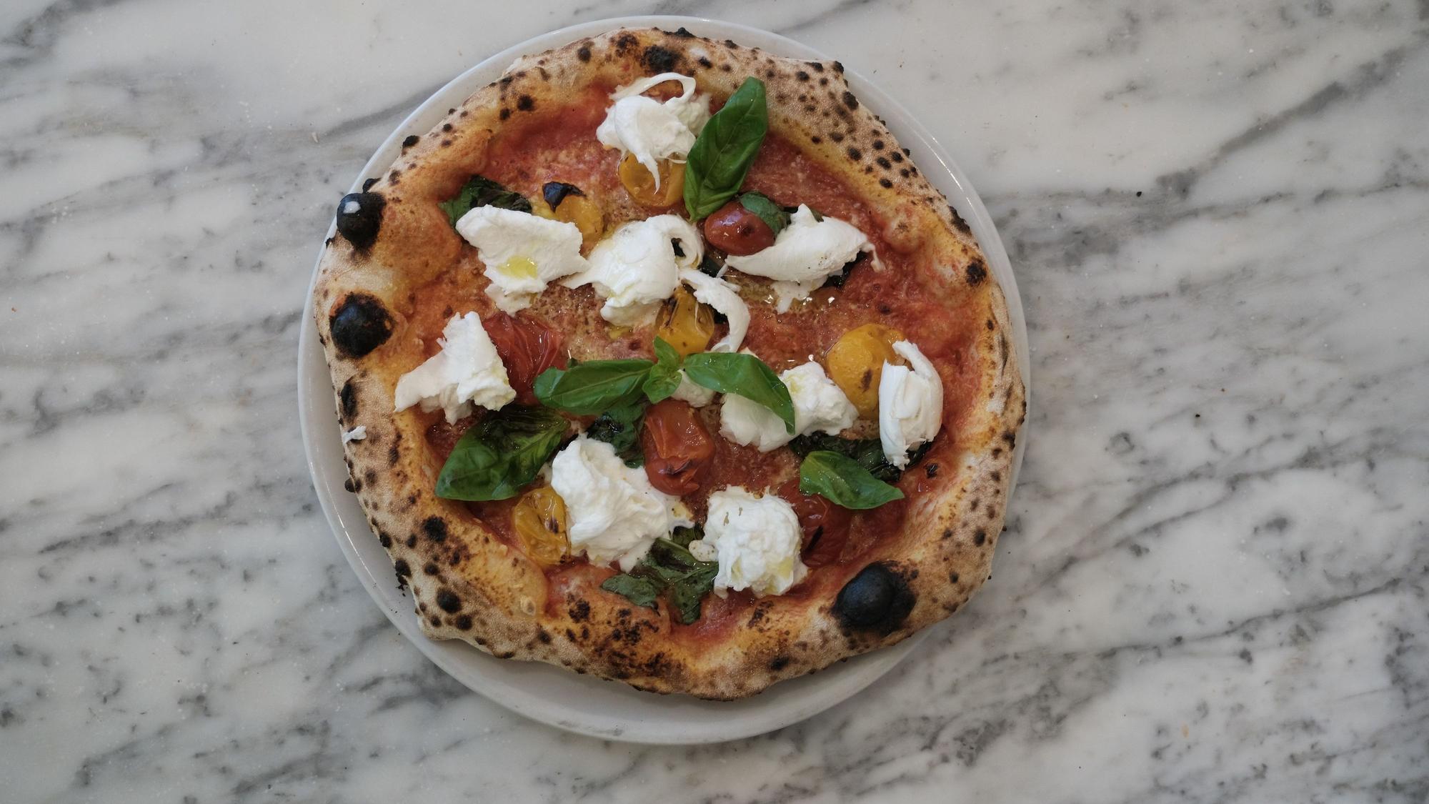 Pizza mit Mozzarella, Tomaten und Basilikum