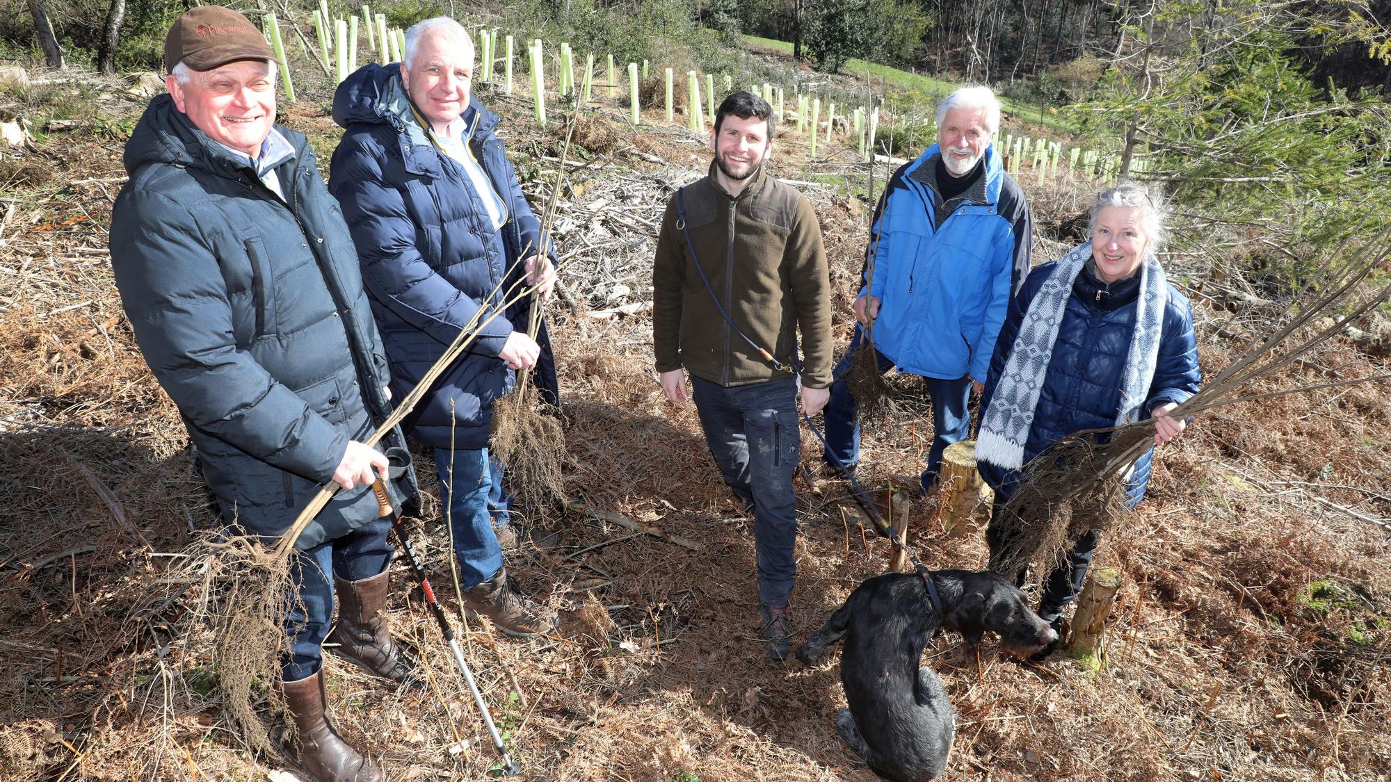 Die Beteiligten des Projekts stehen auf einer Waldfläche.