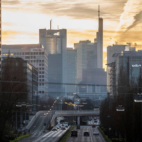 Man sieht die Skyline des Frankfurter Bankenviertels gegen den Sonnenaufgang.