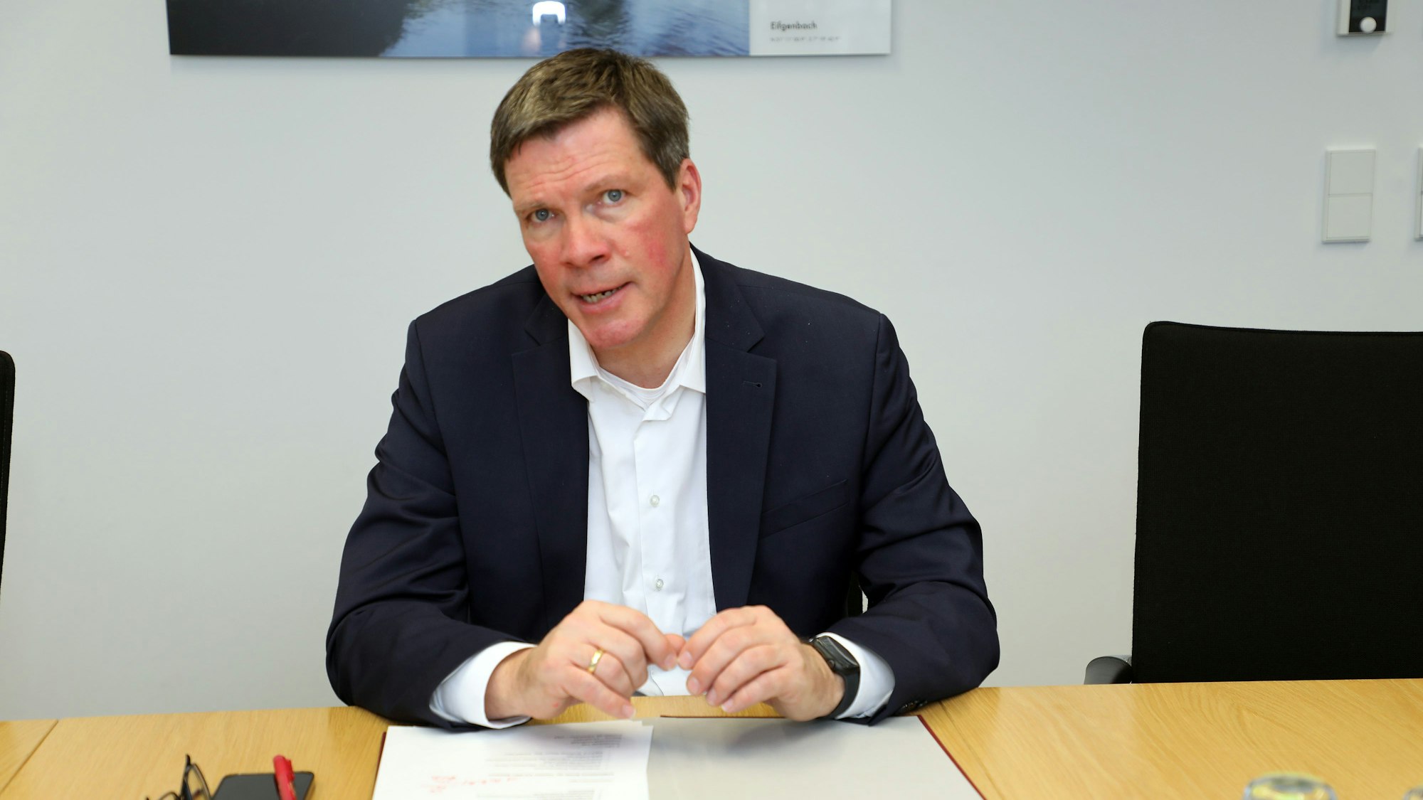 Landrat Stephan Santelmann sitzt an einem Tisch.