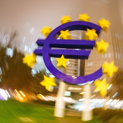 Man sieht das Euro-Denkmal im Zentrum, das Bild außenrum verschwimmt.