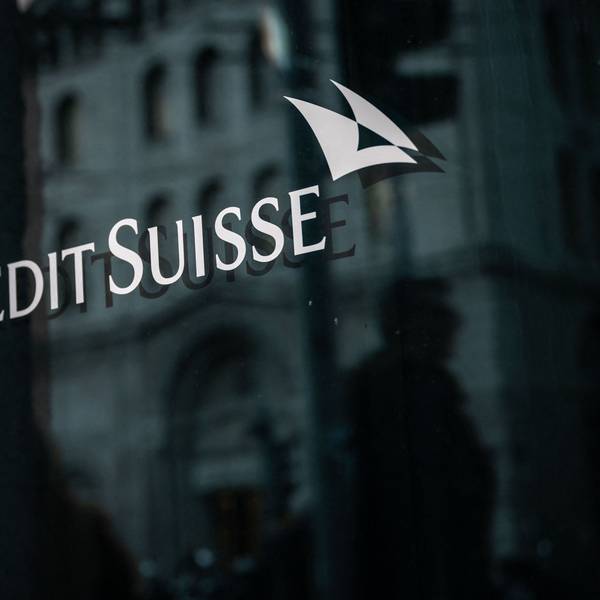 Man sieht das Banklogo weiß auf schwarz auf einer polierten Wand.