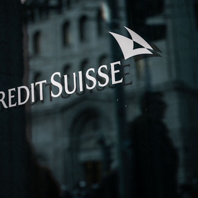 Man sieht das Banklogo weiß auf schwarz auf einer polierten Wand.