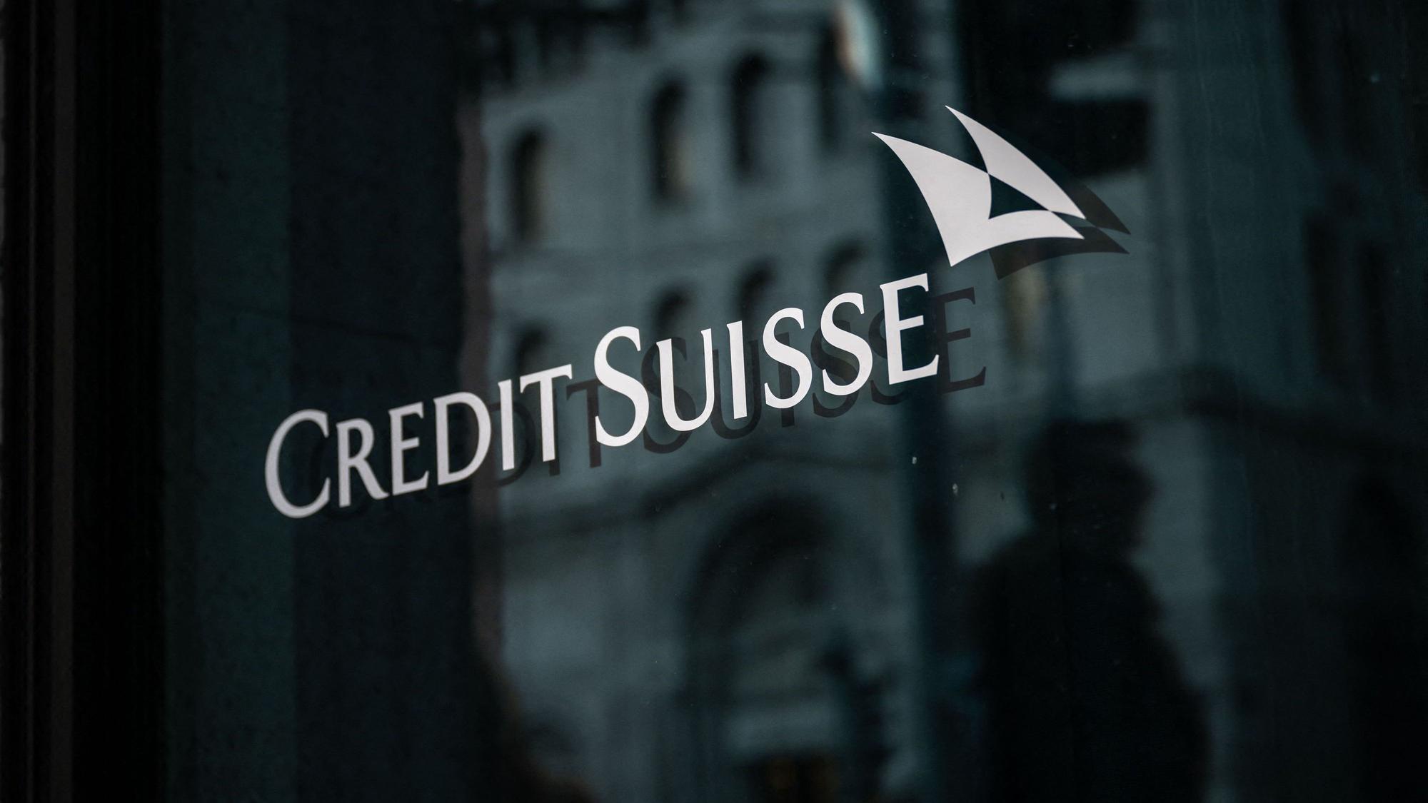 Man sieht das Banklogo weiß auf schwarz auf einer polierten Wand.