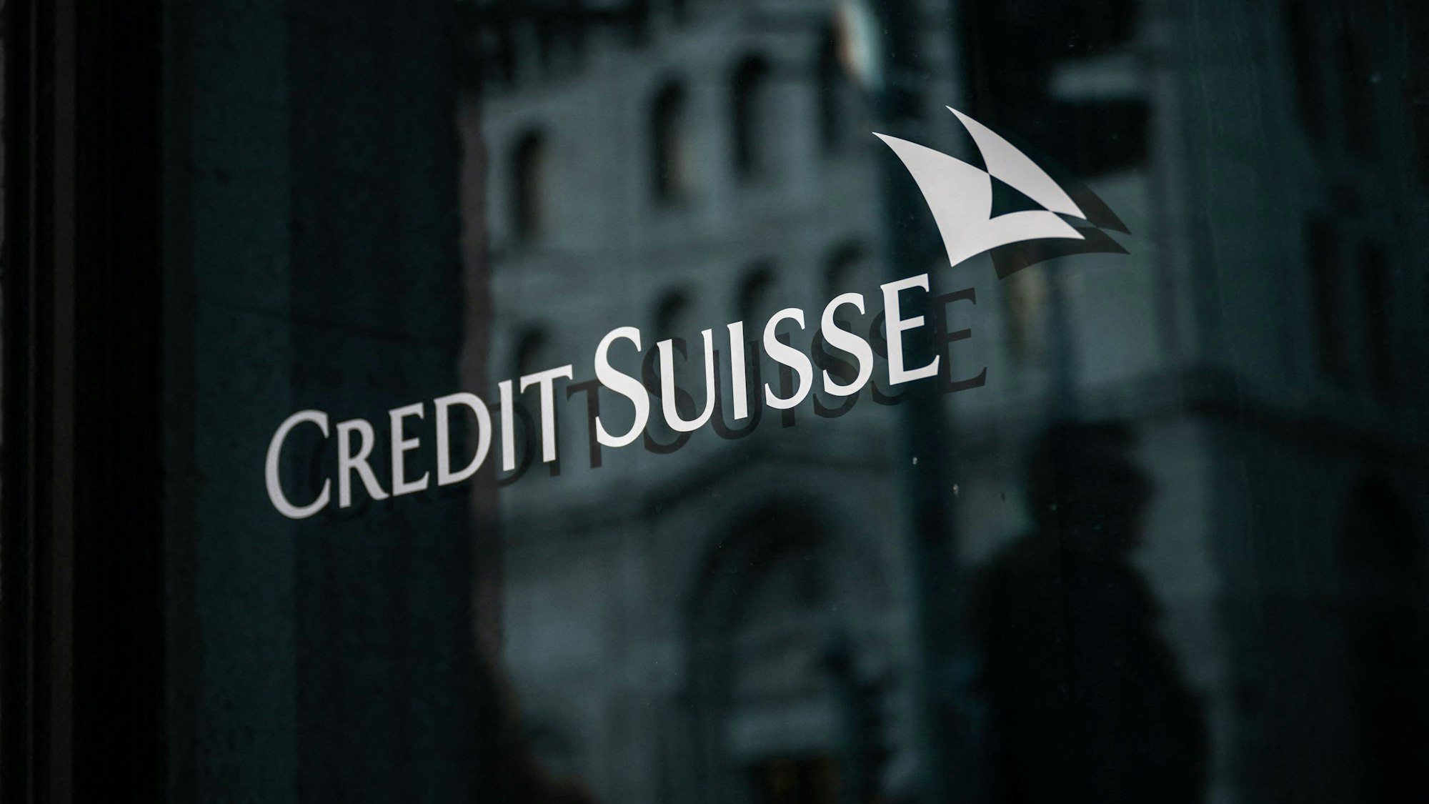 Man sieht das Banklogo weiß auf schwarz auf einer polierten Wand.