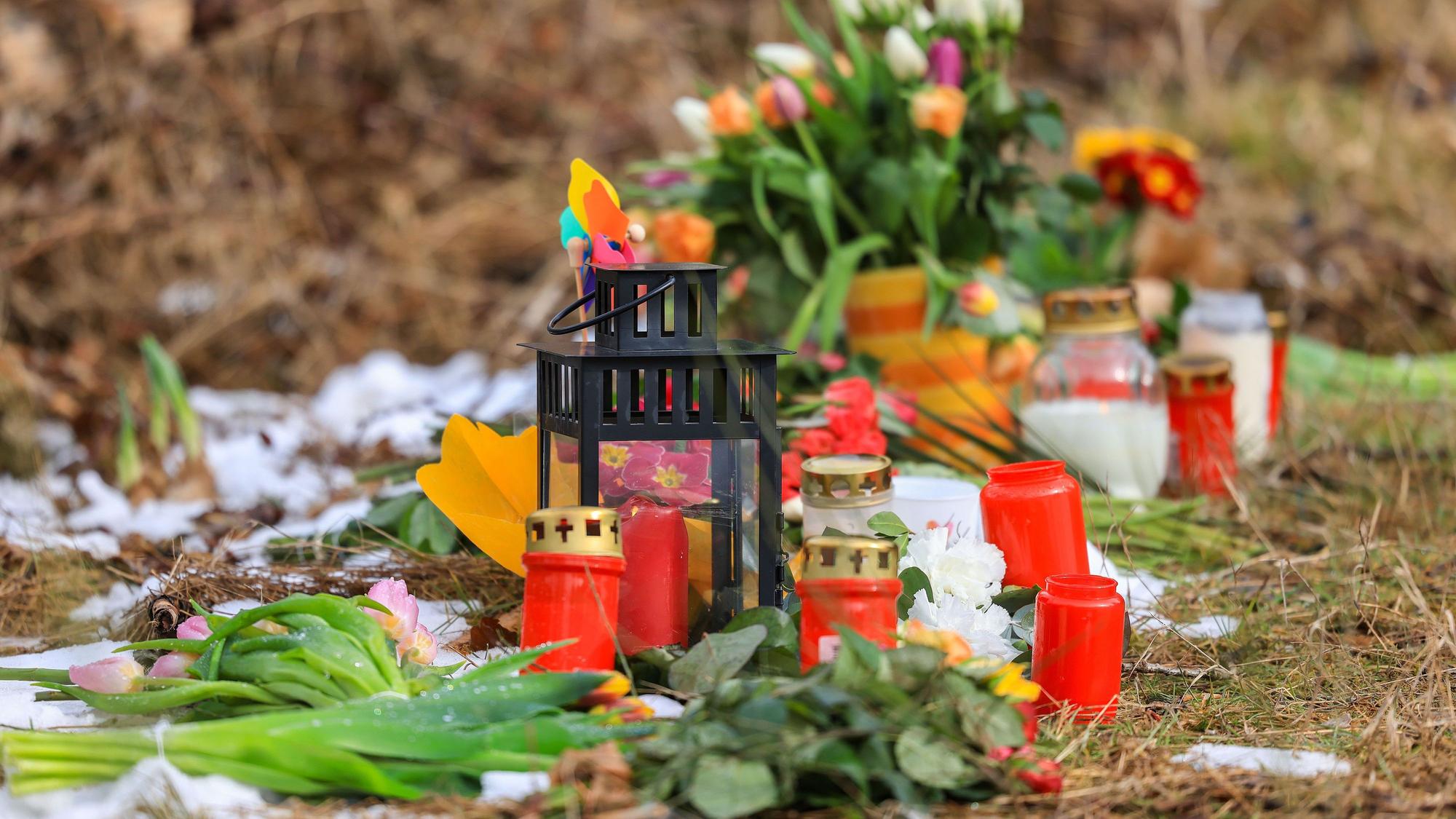 Kerzen und Blumen stehen am Tatort.