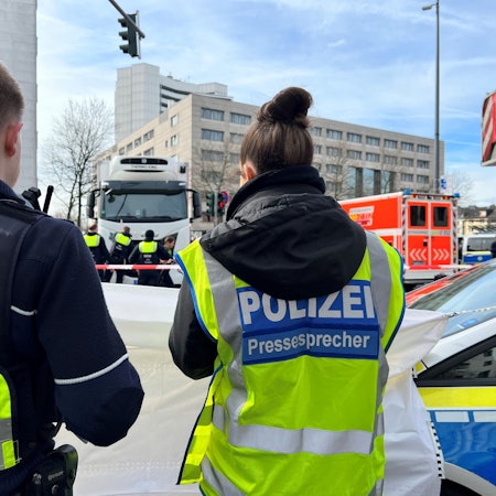 Einsatzkräfte der Polizei stehen am Wiener Platz.