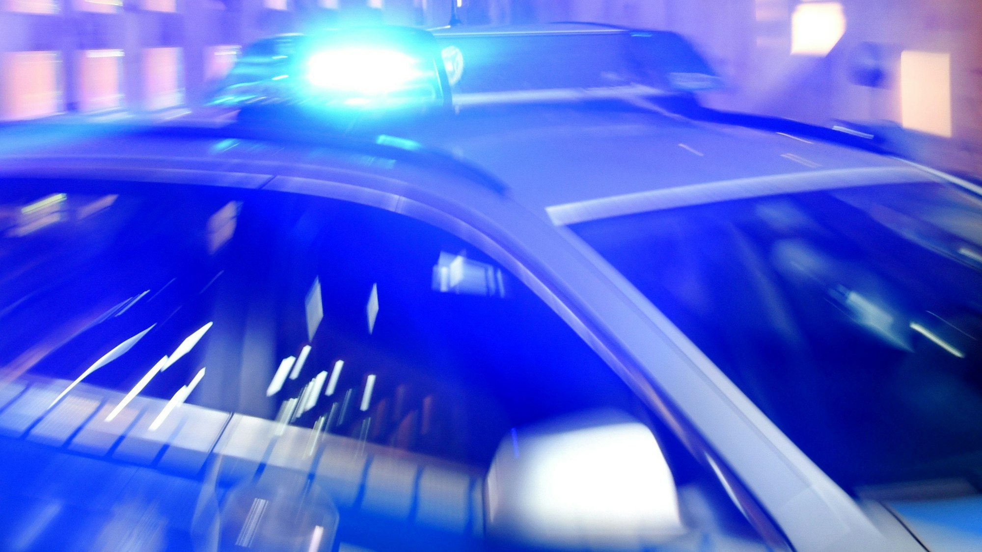 Blaulicht leuchtet auf einem Streifenwagen der Polizei.