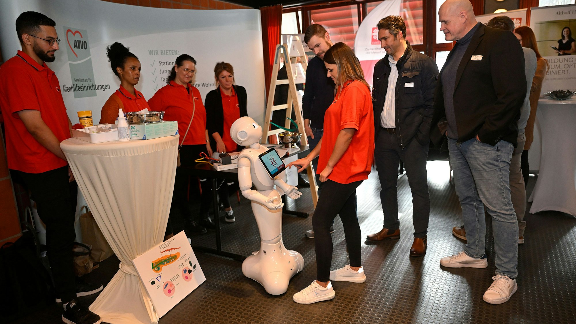 Mehrere Menschen stehen um einen Pflegeroboter herum.