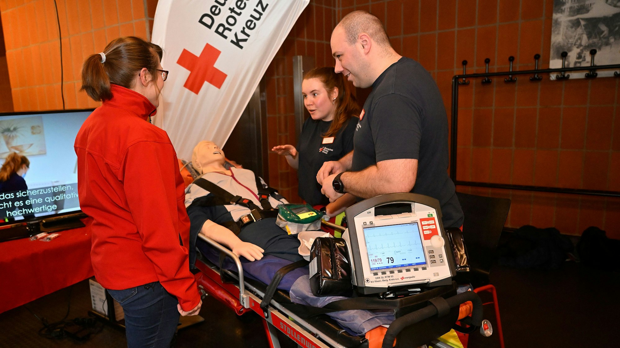 Menschen stehen um eine Liege mit einer Simulationspuppe herum.