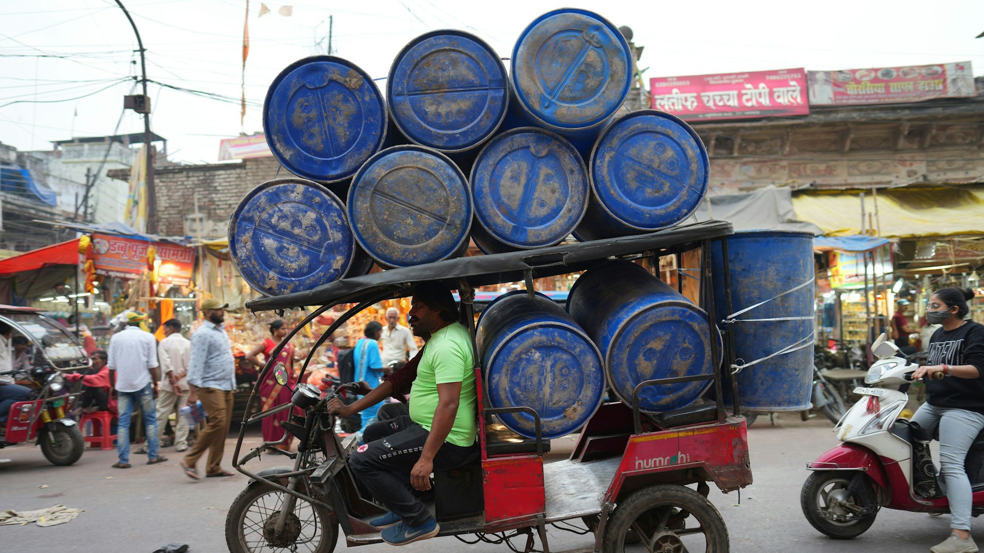 Indien, Prayagraj: Eine elektrische Rikscha transportiert Fässer