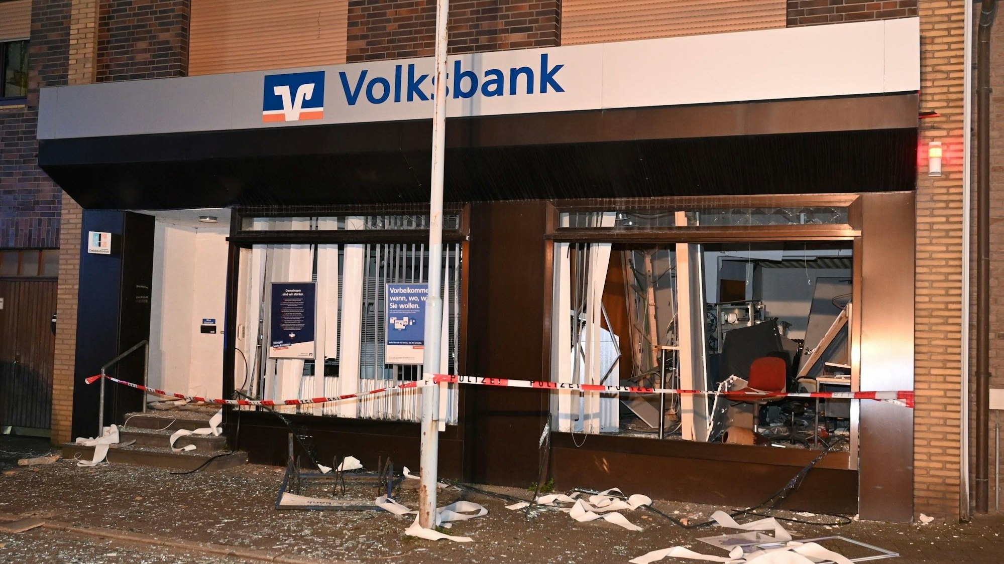 Die Volksbank-Filiale in Frontansicht. Überall liegen Trümmer und Glasscherben.