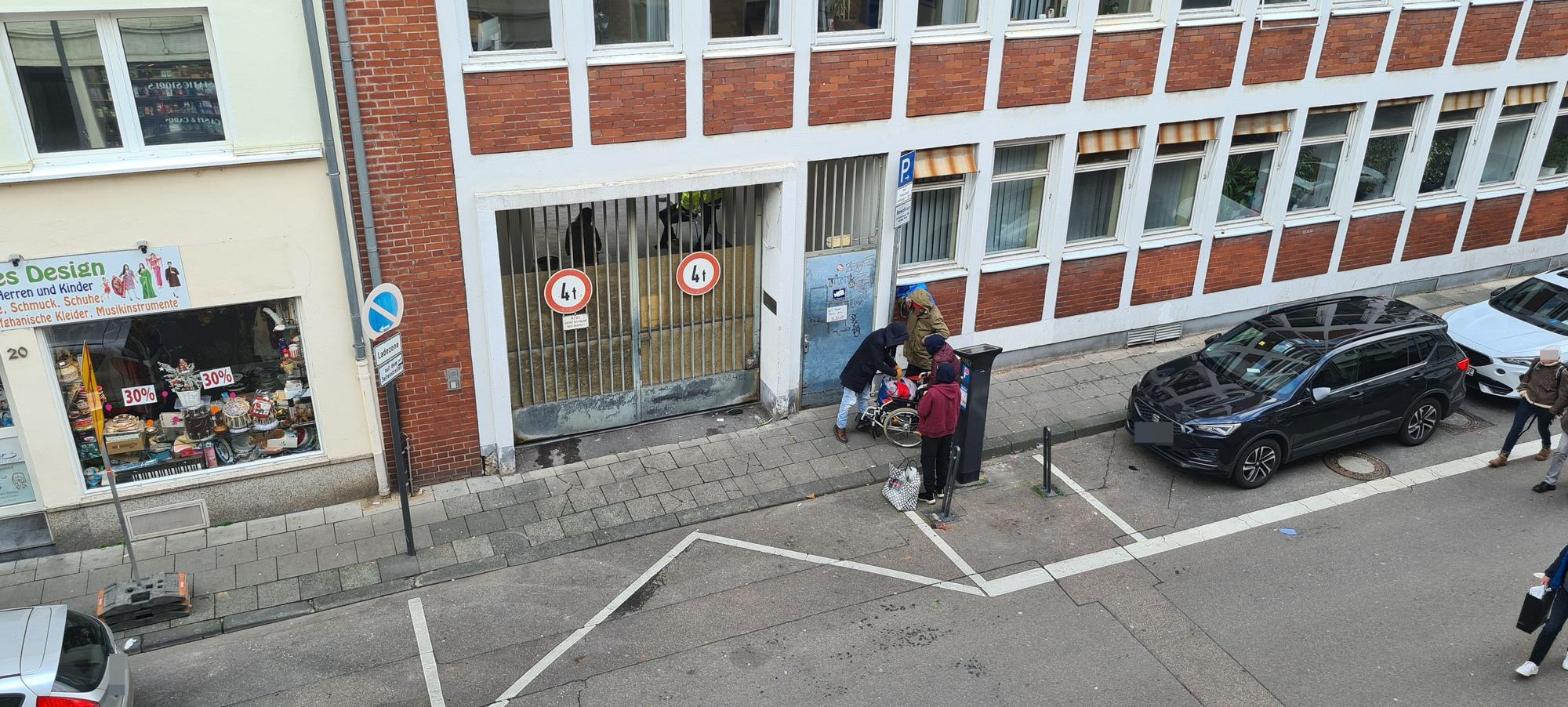 Drogenabhängige Menschen warten vor der verschlossenen Tür zum Drogenkonsumraum am Kölner Neumarkt.