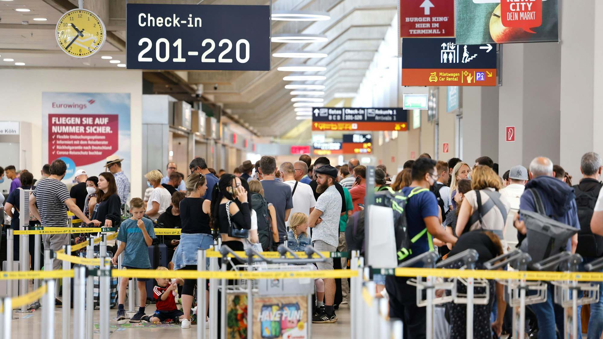 25.06.2022, Nordrhein-Westfalen, Köln: Passagiere stehen am Samstag Vormittag in einer Schlange von mehreren hundert Metern für die Sicherheitskontrolle am Flughafen Köln Bonn an.