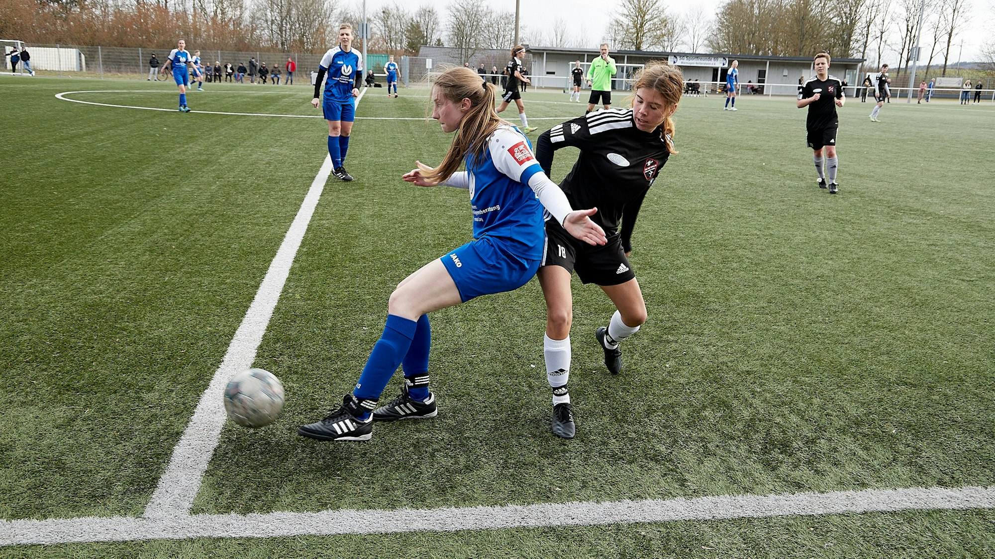 Das Bild zwei Fußballerinnen im Kampf um den Ball an der Außenlinie.