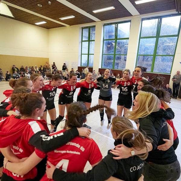 Die Volleyballerinnen aus Marmagen und ihre Trainerinnen bilden einen Kreis und jubeln über den Aufstieg.