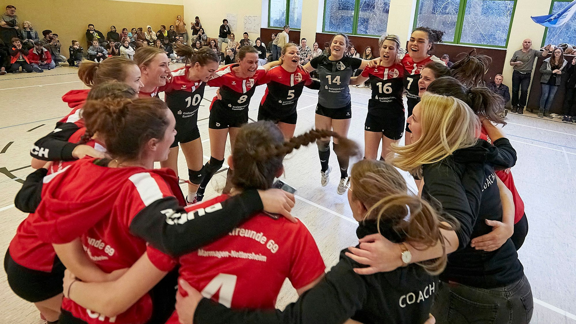 Die Volleyballerinnen aus Marmagen und ihre Trainerinnen bilden einen Kreis und jubeln über den Aufstieg.
