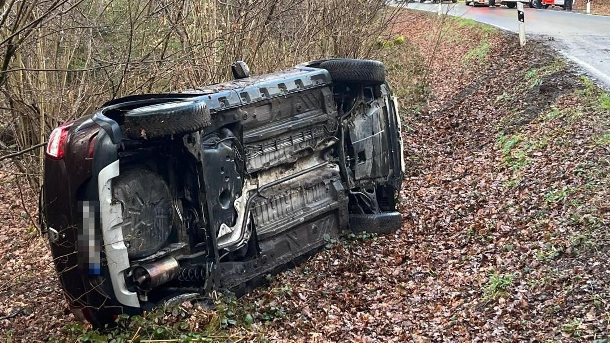 Ein Auto liegt im Straßengraben.