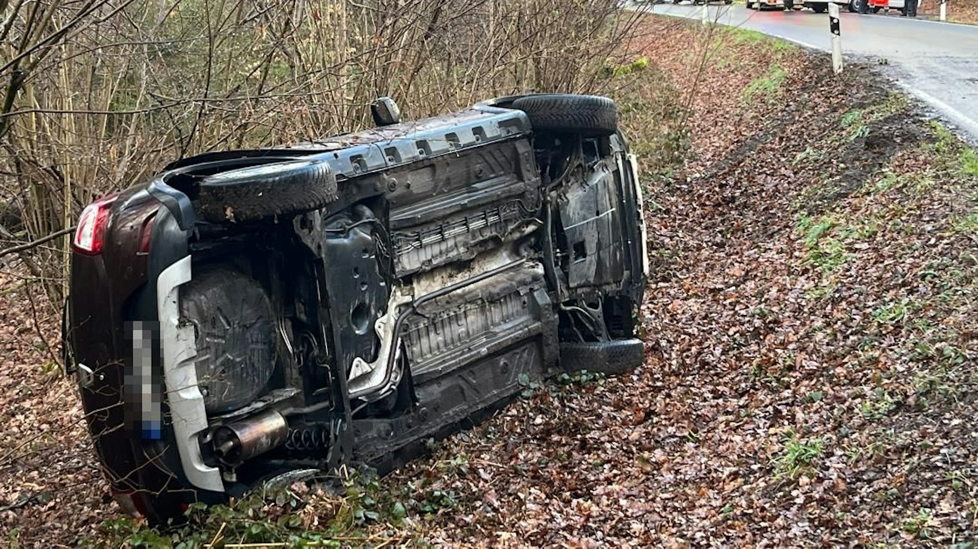 Ein Auto liegt im Straßengraben.