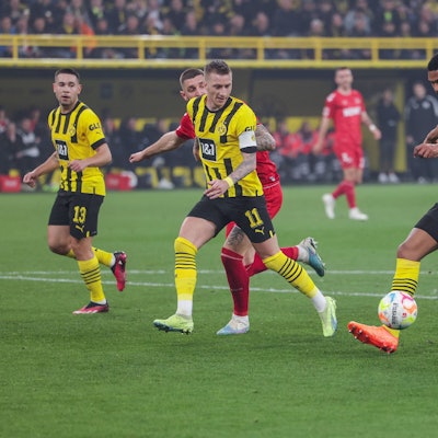 Drei Spieler von Dortmund laufen mit dem Ball nach vorne, sodass der Kölner Spieler nicht an den Ball kommt.