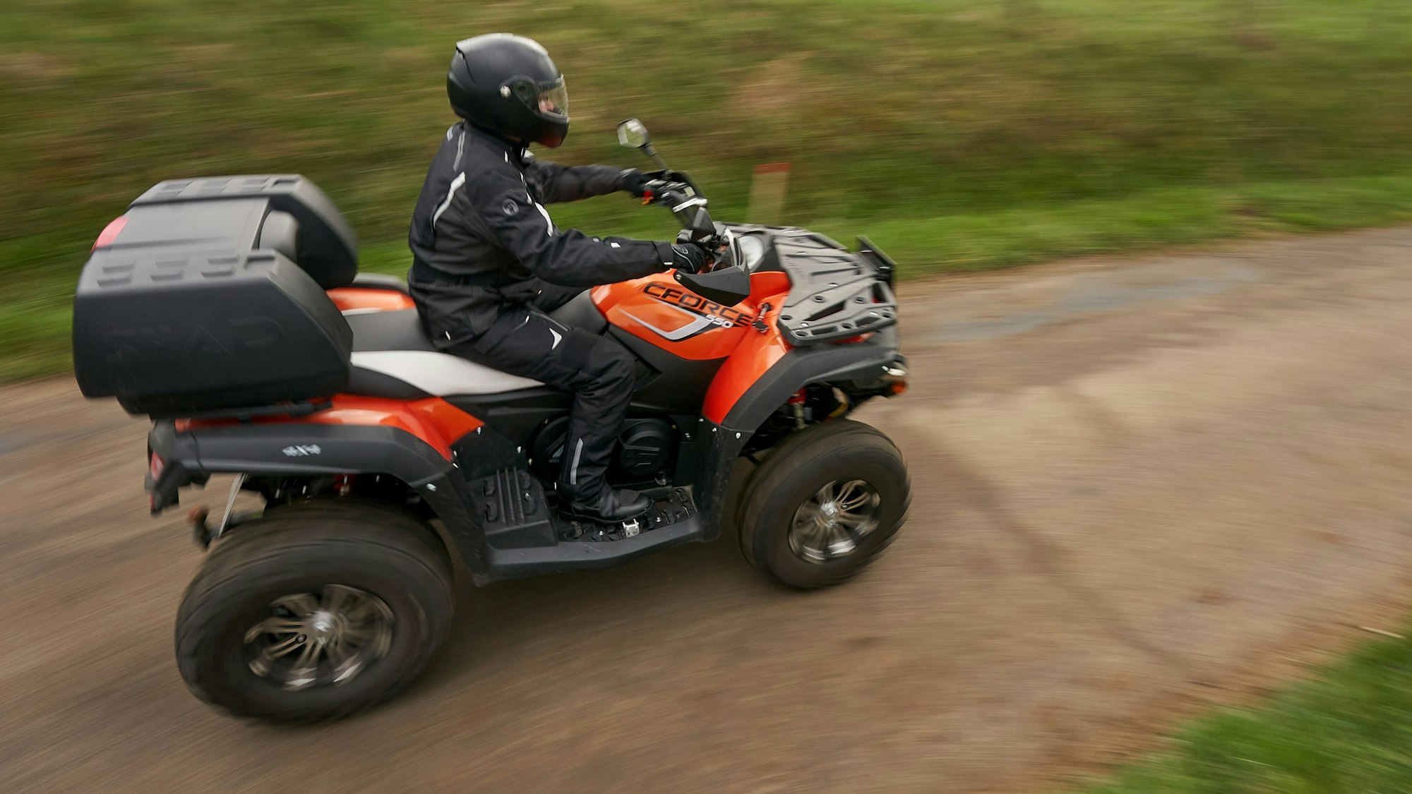 Ein Quadfahrer ist auf einer Landstrasse unterwegs.