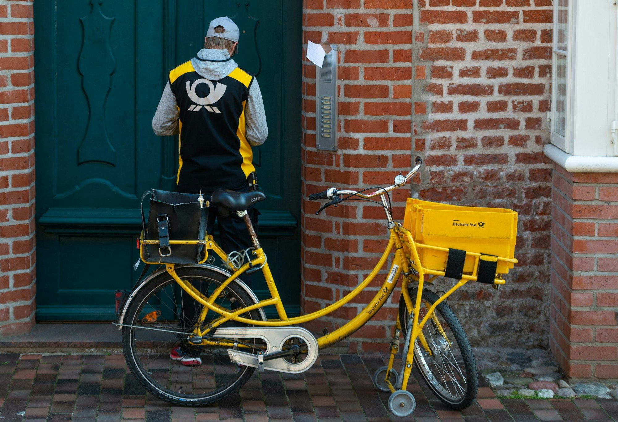 Ein Postbote verteilt Briefe in der historischen Innenstadt von Lüneburg.