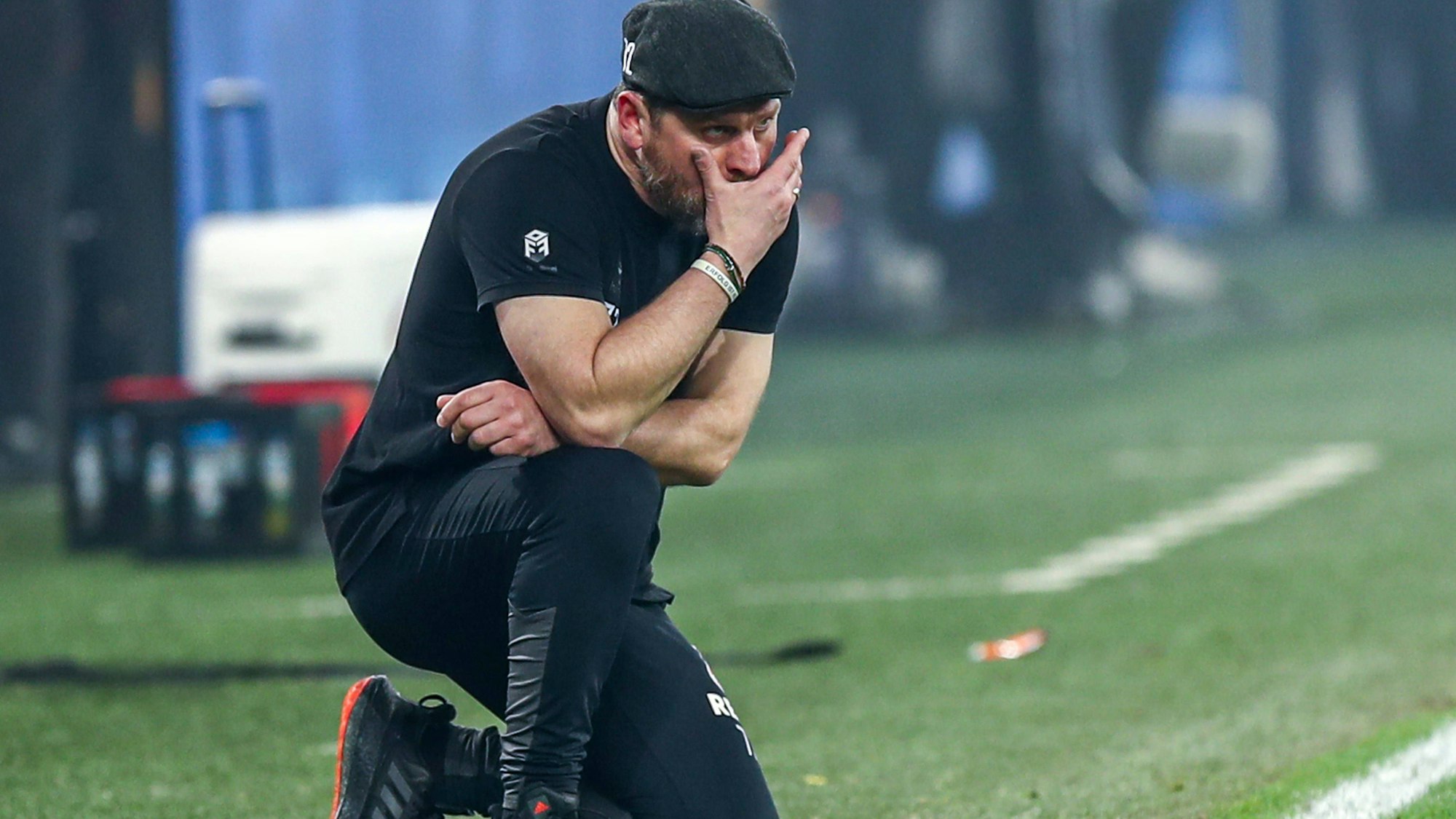 Trainer Steffen Baumgart hockt beim Spiel des 1. FC Köln bei Borussia Dortmund nachdenklich an der Seitenlinie.