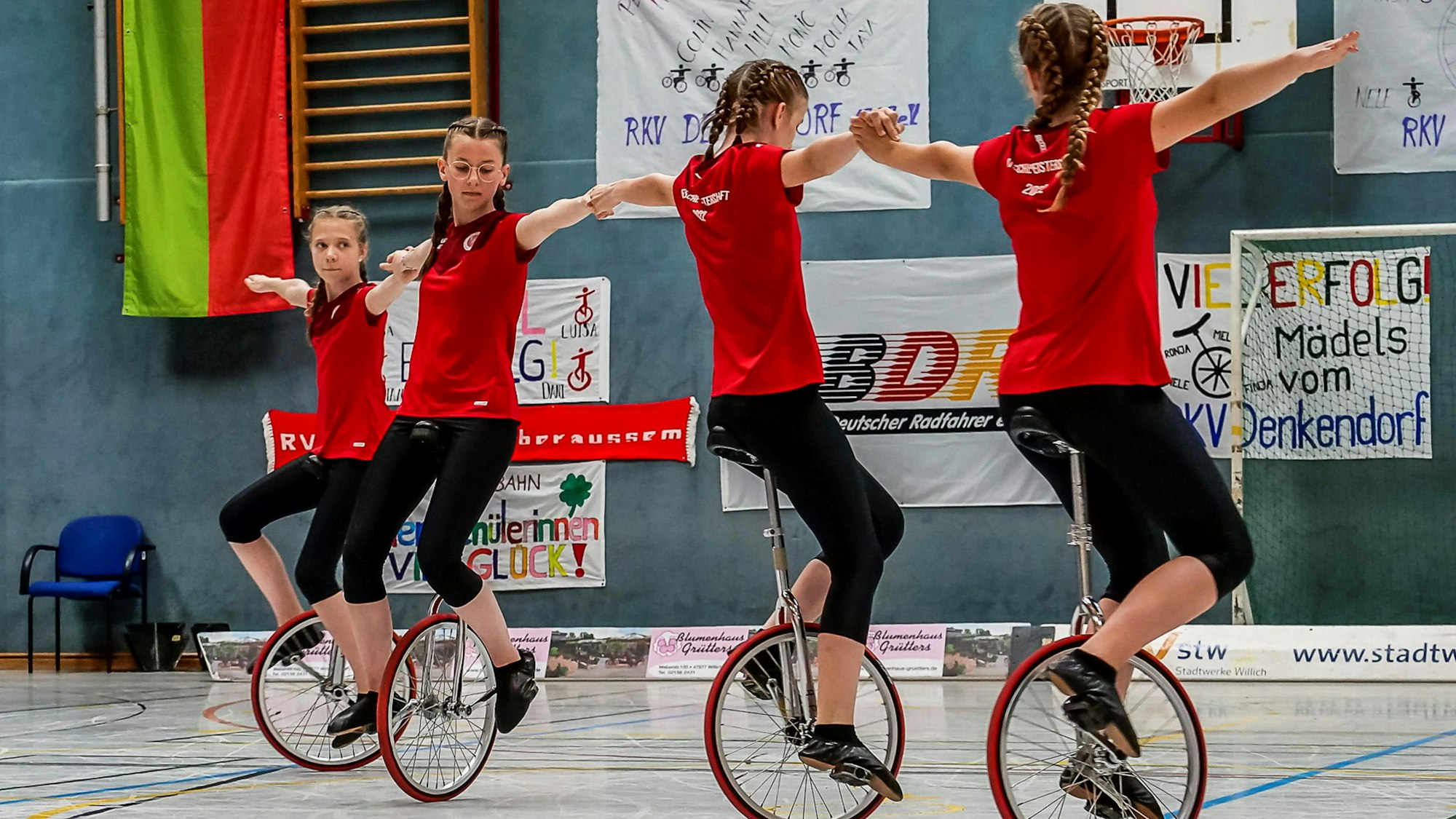 Vier Einradfahrerinnen in einer Linie