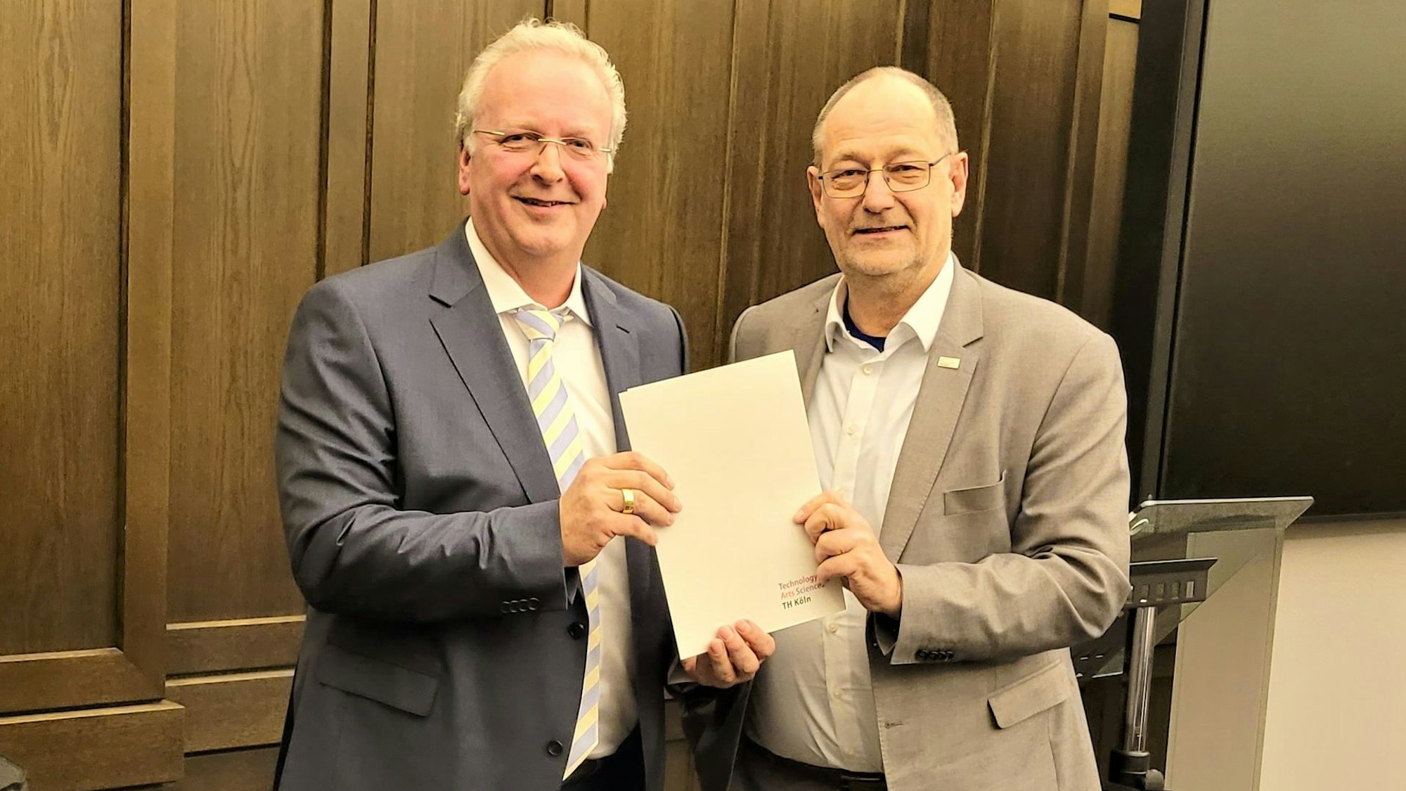 Prof. Dr. Stefan Herzig, Präsident der TH Köln, übergibt Uwe Ufer eine Urkunde.