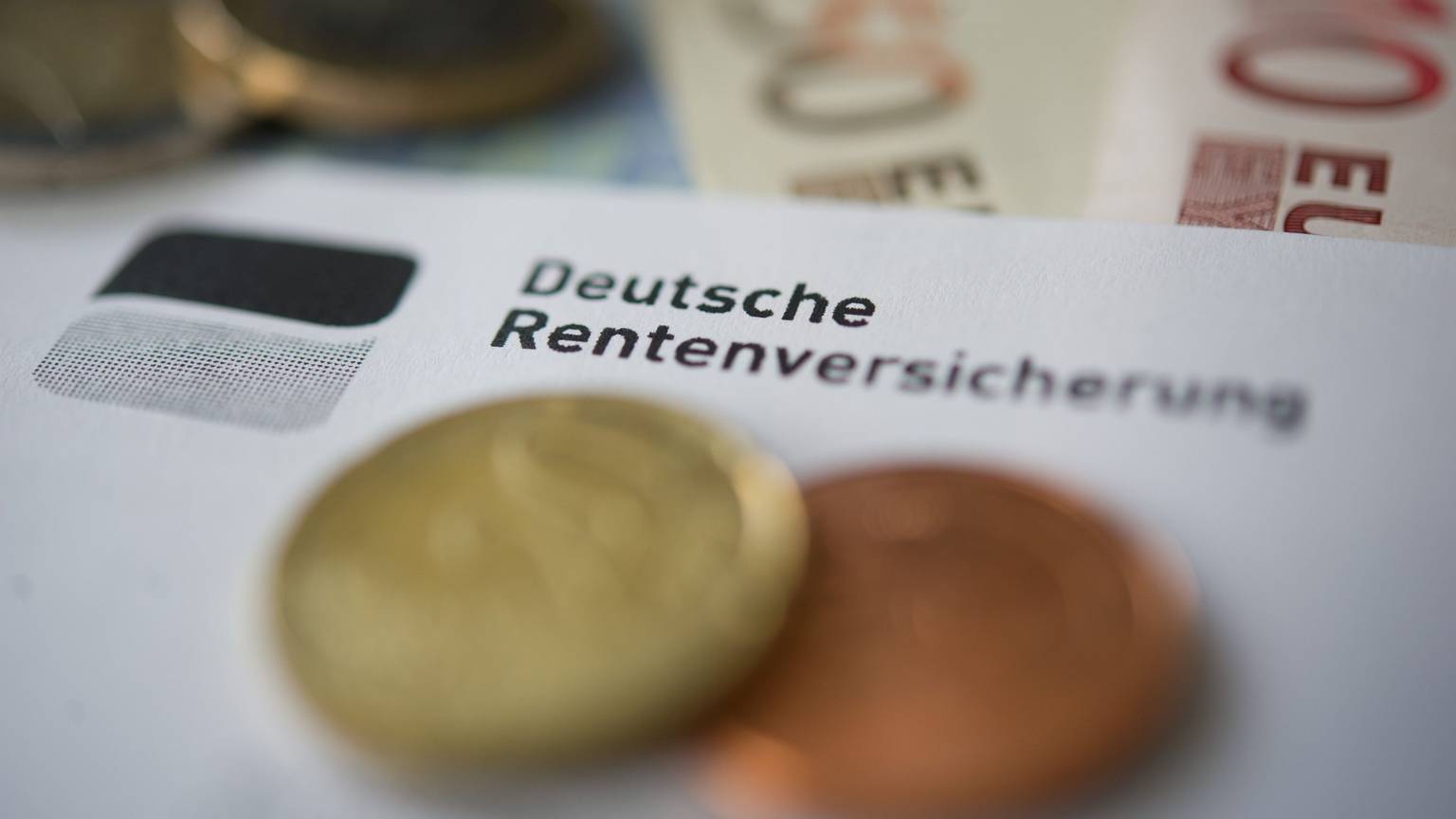 Auf einem Papier mit der Aufschrift Deutsche Rentenversicherung liegen Cent-Stücke.