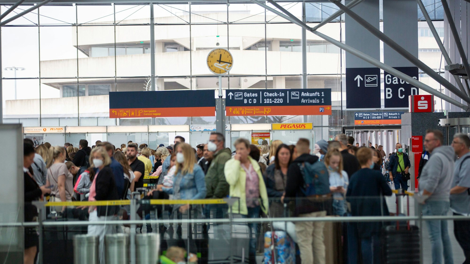 Sommer 2022: Flugreisende warten in einer langen Schlange vor Check-in-Schaltern am Flughafen Köln/Bonn.