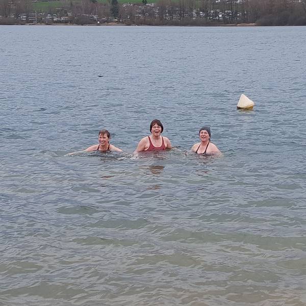 Drei Frauen baden in dem Gewässer.