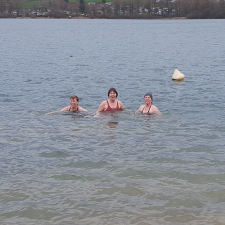 Drei Frauen baden in dem Gewässer.