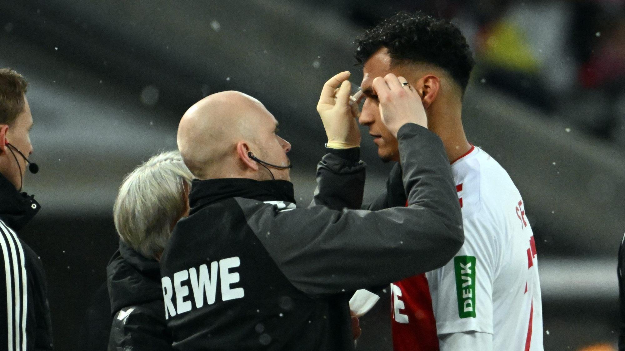 Davie Selke wird vom Mannschaftsarzt im Gesicht versorgt.