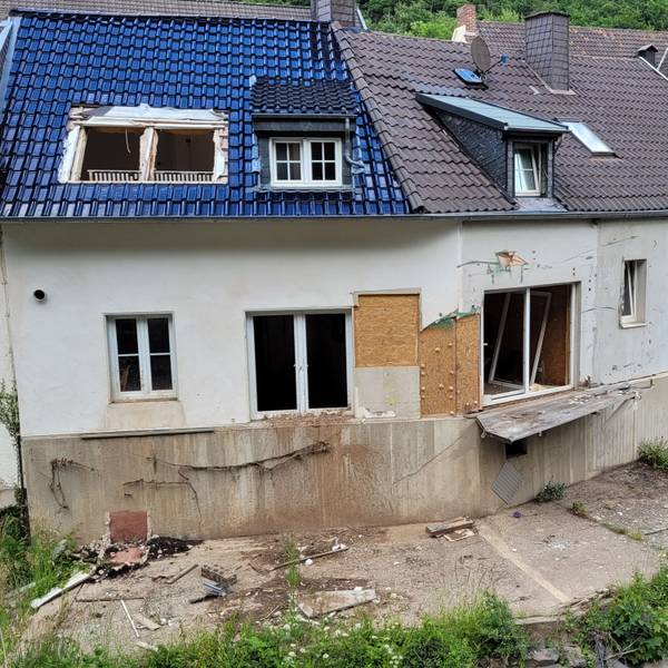 Das Bild zeigt ein Fluthaus mit kaputten Fenstern und Türen.