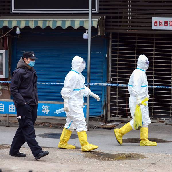 Wuhan: Arbeiter in Schutzkleidung tragen eine Tasche vom Huanan Seafood Market. Vorläufige Ergebnisse einer neuen genetischen Untersuchung stützen die Vermutung eines natürlichen Ursprungs von Sars-CoV-2.