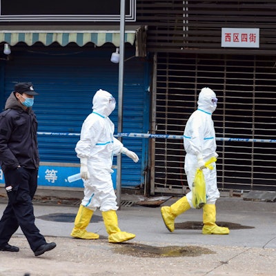 Wuhan: Arbeiter in Schutzkleidung tragen eine Tasche vom Huanan Seafood Market. Vorläufige Ergebnisse einer neuen genetischen Untersuchung stützen die Vermutung eines natürlichen Ursprungs von Sars-CoV-2.