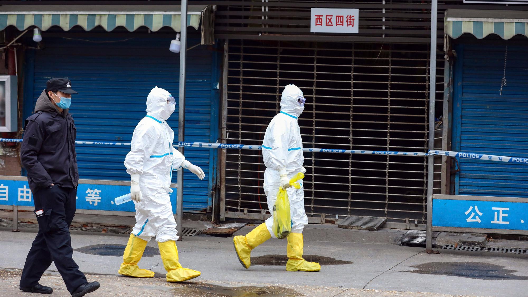 Wuhan: Arbeiter in Schutzkleidung tragen eine Tasche vom Huanan Seafood Market. Vorläufige Ergebnisse einer neuen genetischen Untersuchung stützen die Vermutung eines natürlichen Ursprungs von Sars-CoV-2.