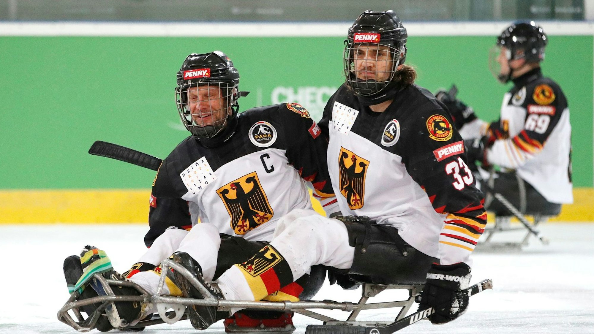 Zu sehen sind zwei Spieler der deutschen Para-Eishockey-Nationalmannschaft in ihren Sportschlitten.