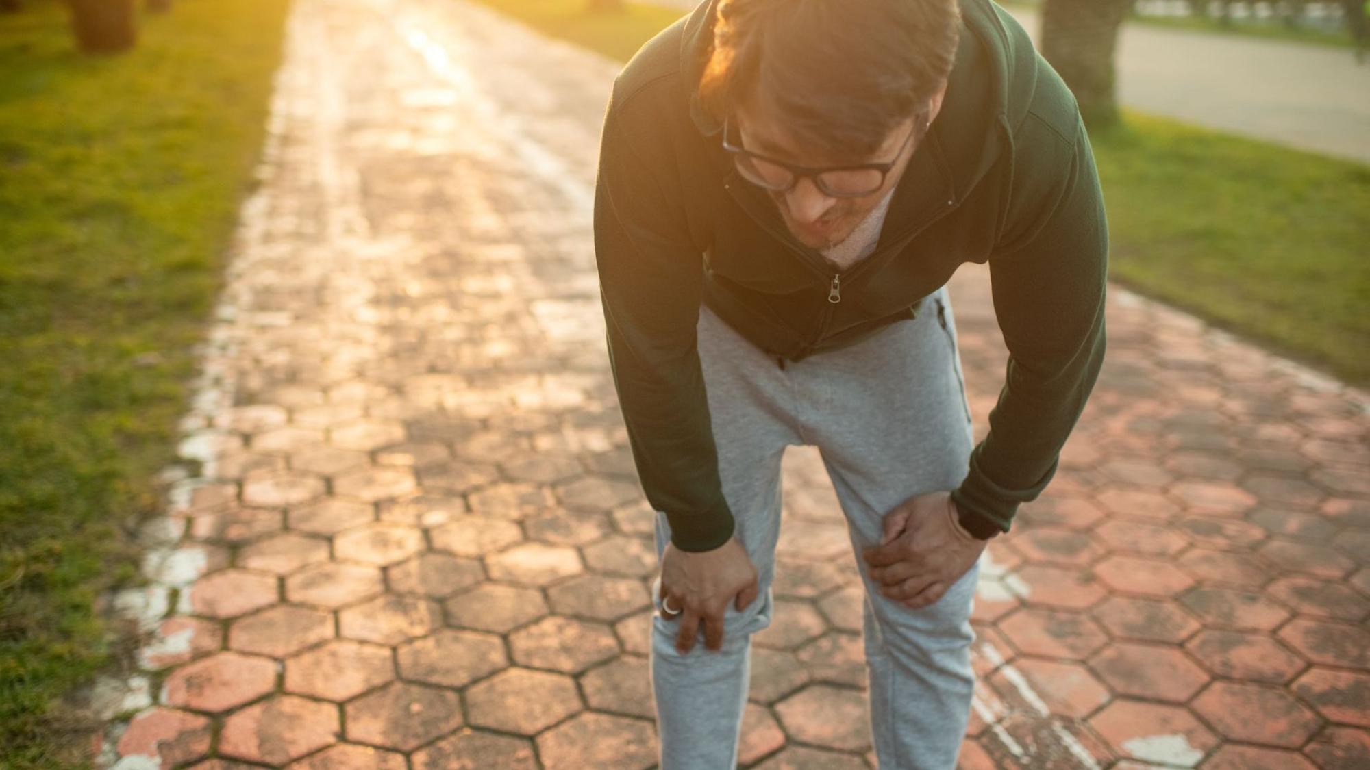 Mann in Joggingkleidung sieht erschöpft aus.