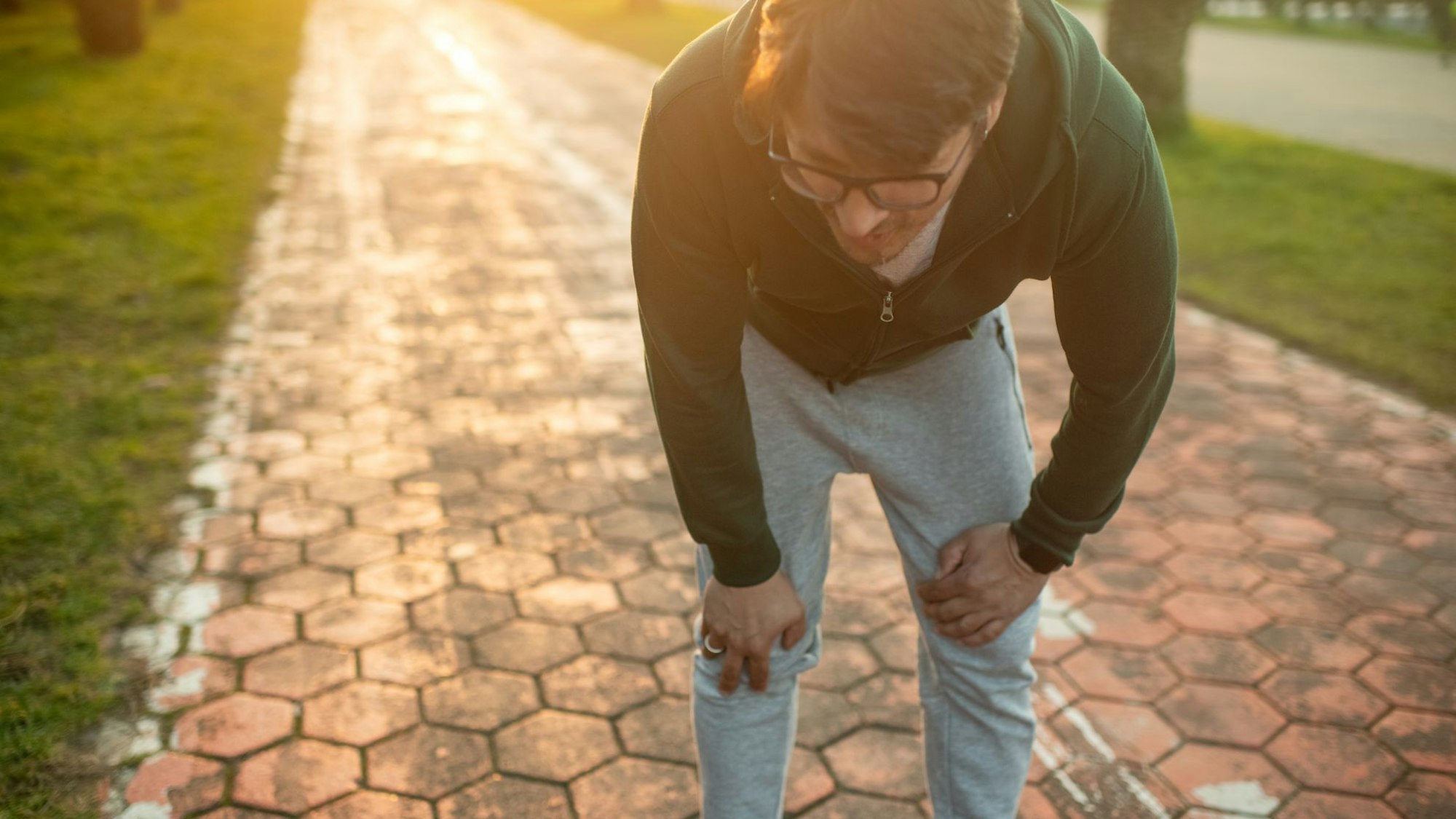 Mann in Joggingkleidung sieht erschöpft aus.