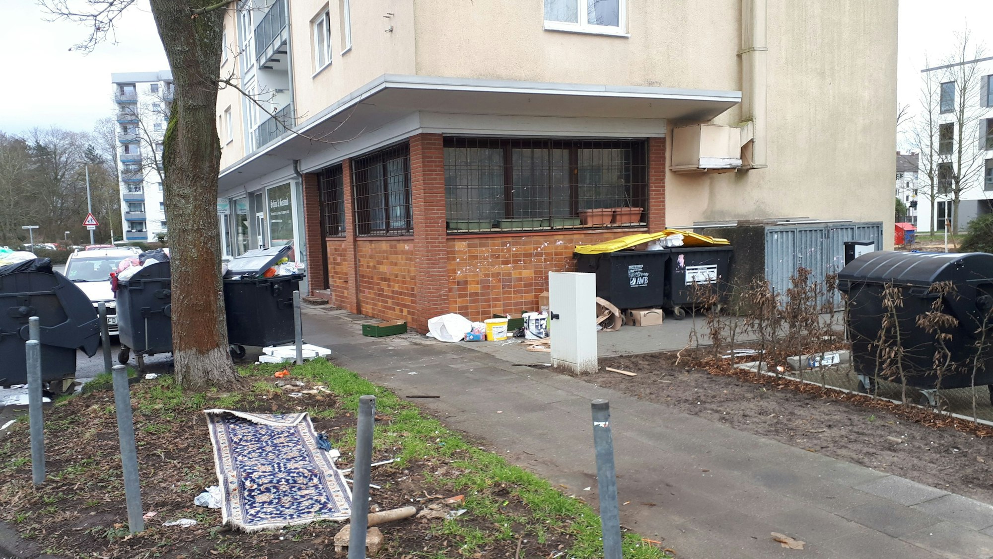 Das Bild zeigt das Haus August-Haas-Straße 1, mit der leerstehenden Gaststätte im Erdgeschoss. In der Umgebung sammelt sich der Müll.