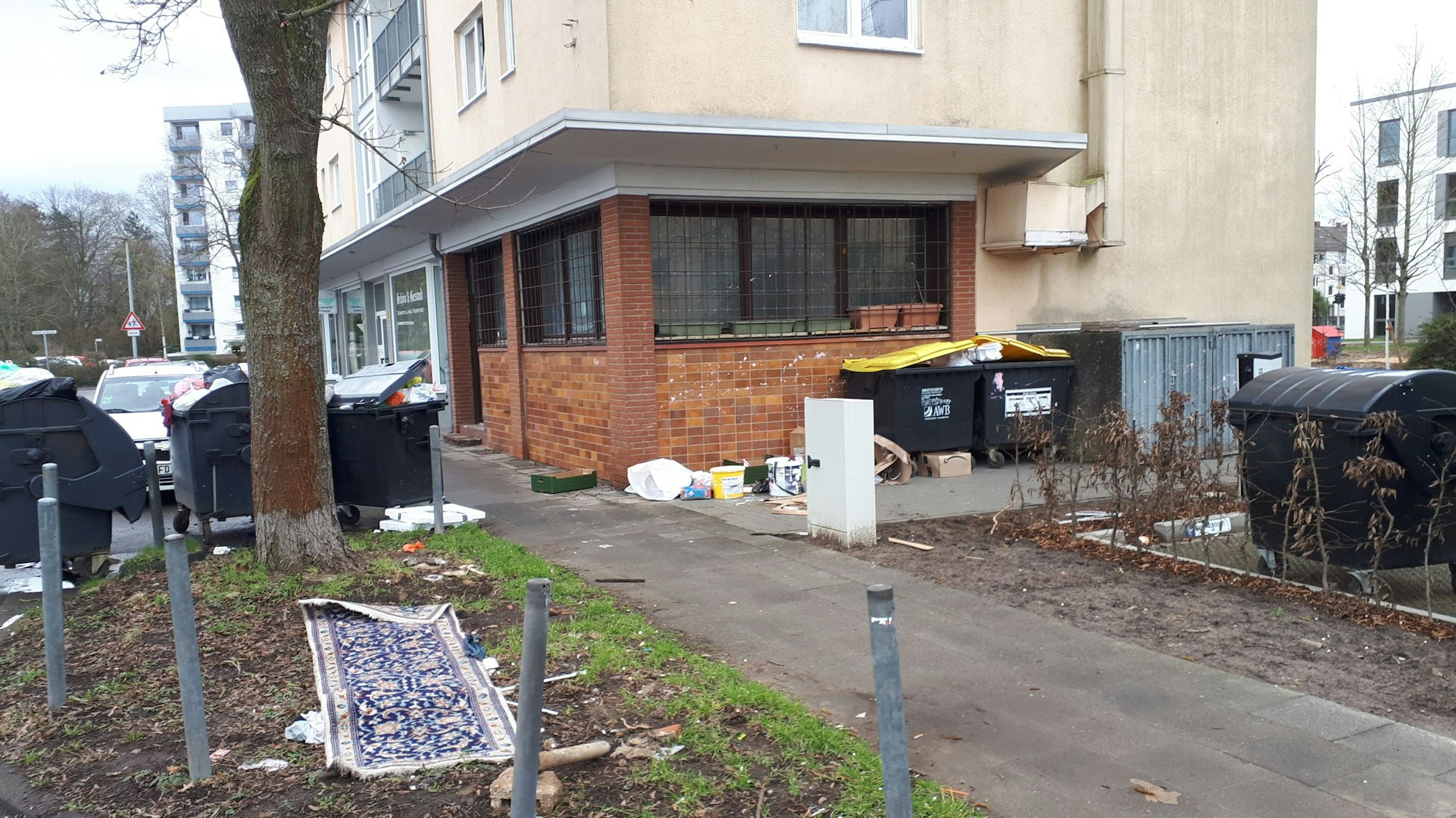 Das Bild zeigt das Haus August-Haas-Straße 1, mit der leerstehenden Gaststätte im Erdgeschoss. In der Umgebung sammelt sich der Müll.