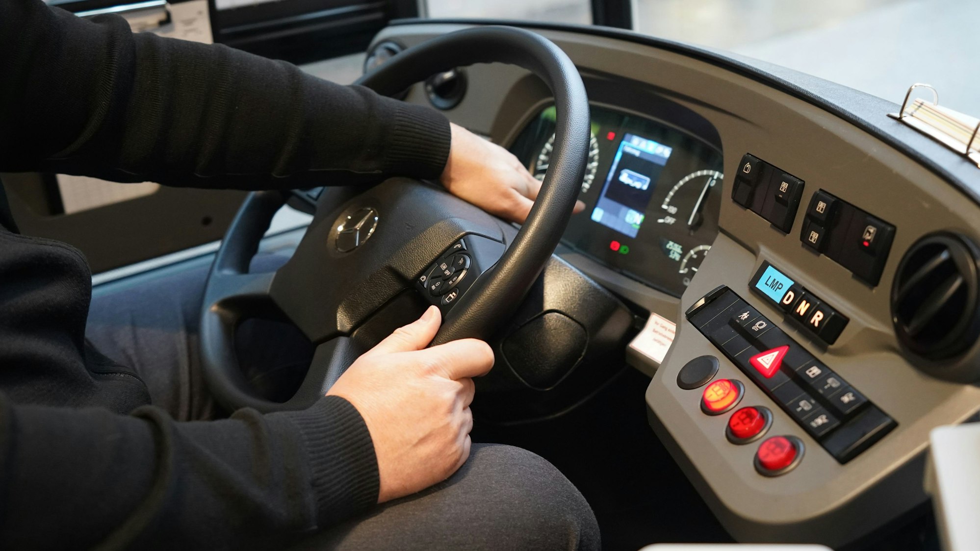 Ein Busfahrer sitzt in einem Elektrobus.